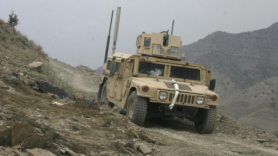 Military vehicle in mountainous terrain.