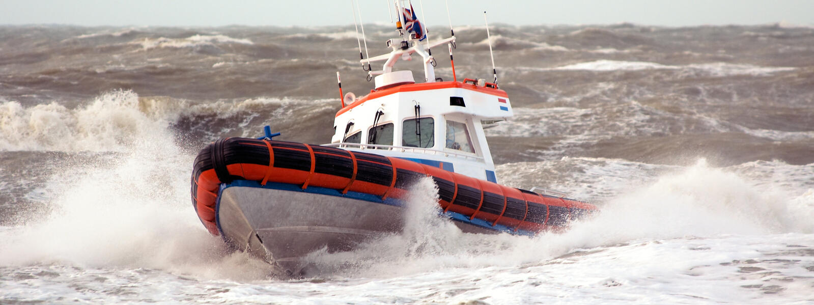 Coast guard boat in stormy waves.